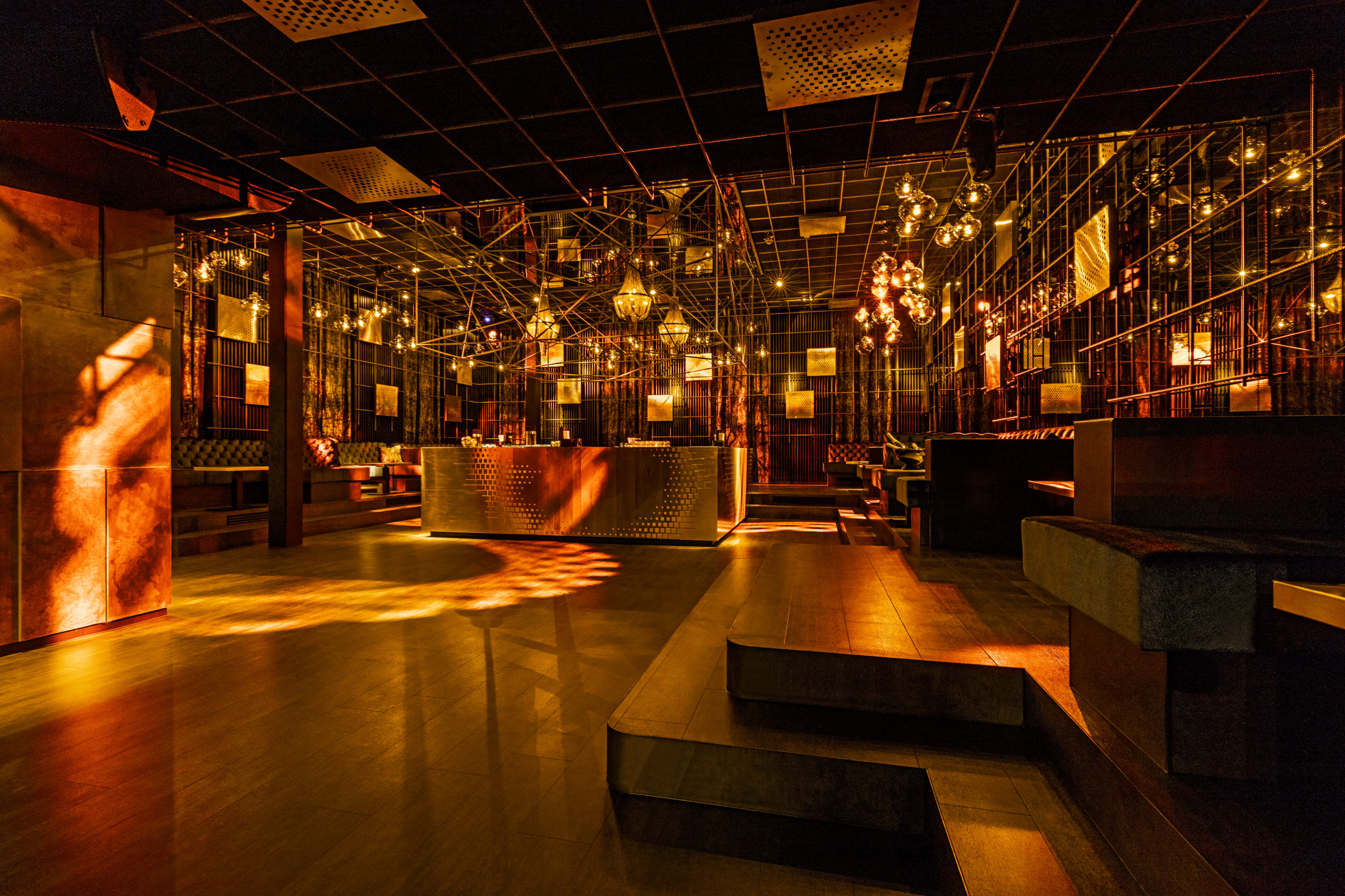 Elegante Lounge mit warmem Licht, stilvollem Barbereich und modernen Sitzgelegenheiten.