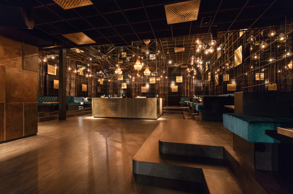 Elegantes Restaurant mit stilvollem Empfangstresen, ged&auml;mpfter Beleuchtung und modernen Sitzbereichen.